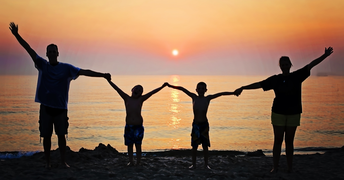 Silhouette of a Family by the Sea at Sunset